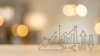 Business growth chart with upward arrows and bar graphs on wooden surface with warm bokeh lights background for financial success presentations.