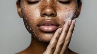 Young African American woman with closed eyes touching face covered in water droplets for skincare and beauty routine concepts.