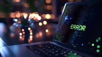 Laptop computer displaying green error message on dark screen with bokeh lights in background creating moody tech atmosphere for troubleshooting concepts.