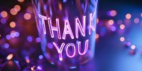 Glowing neon thank you sign with purple and pink bokeh lights creating magical atmosphere for greeting cards and appreciation messages.