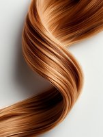 Smooth wavy strand of honey blonde hair flowing against white background, showcasing natural shine and healthy texture for beauty and haircare advertising.