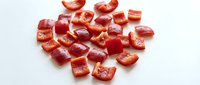 Fresh diced red tomatoes chopped into small cubes on white background, isolated for cooking and culinary design projects.