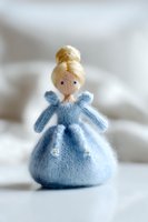 Handmade knitted princess doll in blue dress with blonde hair bun, soft toy craft project on white background for children nursery decor and DIY inspiration.