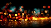 Abstract bokeh lights background with warm orange yellow and teal blue glowing circles creating magical atmosphere for festive celebrations and events.