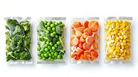 Fresh frozen vegetables and fruits in plastic bags arranged in row showing broccoli, green peas, carrots, and corn kernels on white background.