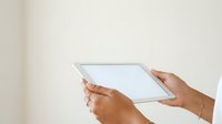 Close-up of hands holding blank tablet device against neutral background, suitable for technology, business, and digital app mockup projects.