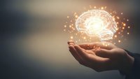 Human hand holding glowing brain hologram with sparkling light effects representing artificial intelligence, innovation and mental power concepts.
