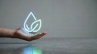 Young adult male hand holding glowing neon leaf and water droplet symbol representing eco-friendly sustainability, renewable energy, and environmental conservation concepts for green business.