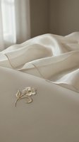 Luxurious cream linen fabric with delicate embroidered floral detail, soft folds and natural light. Perfect for bedding, home decor, textile design and interior styling projects.
