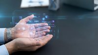 Businessman cupping hands displaying holographic digital network icons and data visualization in modern office environment for technology presentations.