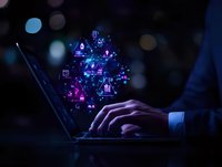 Business person typing on laptop with glowing digital network icons and symbols floating above keyboard in dark blue technological environment.