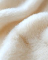 Soft white fluffy fur texture close-up with gentle waves and folds creating an abstract natural pattern background for luxury fashion and cosmetic designs.