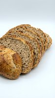 Freshly sliced multigrain bread with seeds and nuts on white background, healthy whole grain bakery product for breakfast and nutrition concepts.