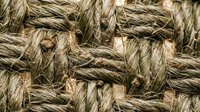 Natural hemp rope texture with twisted fibers in brown and beige tones for nautical, rustic and organic design projects.