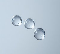 Clear water drops in diagonal line formation on light gray surface create minimalist composition with reflective highlights and subtle shadows.