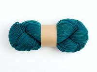 Teal yarn skein with kraft paper band isolated on white background, ready for knitting, crochet, and craft design projects.