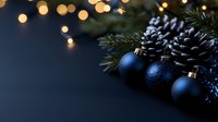 Navy blue Christmas ornaments and frosted pinecones arranged with evergreen branches against dark background with soft bokeh lights creating festive holiday mood.