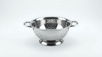 Stainless steel colander with perforated bowl and dual handles for draining pasta, vegetables, and other foods in kitchens.