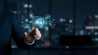 Businessman hand touching digital security shield with network connections and data protection icons in modern office environment for cybersecurity concepts.