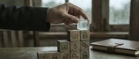 Business professional building wooden blocks tower with icons representing growth strategy and development concepts in modern office environment.
