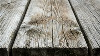 Weathered wooden planks with natural grain texture and rustic cracks, perfect for backgrounds and vintage design projects.