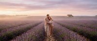 Woman in beige coat standing in blooming lavender field at sunset, romantic countryside landscape for travel and lifestyle content.