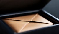 Geometric abstract composition with triangular shapes in warm beige tones against dark background creating minimalist architectural pattern with dramatic lighting.