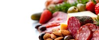 Fresh antipasto platter with cured meats, salami, strawberries, olives, nuts, and cheese on white background. Perfect for gourmet appetizer presentations.