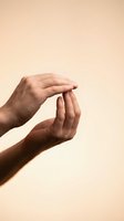 Two cupped hands in protective gesture against warm beige background suggesting care, support and safety in healthcare or wellness concept.