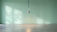Minimalist interior with sage green wall and modern pendant light casting soft shadows on polished concrete floor in empty contemporary room.