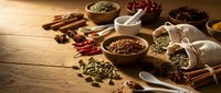 Aromatic spices and herbs collection in wooden bowls on rustic table for cooking, seasoning blends, culinary ingredients and flavor enhancement.