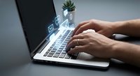 Professional hands typing on modern laptop with glowing email icons floating above keyboard representing digital communication and business correspondence.