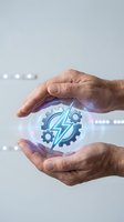 Protective hands surrounding glowing gear and lightning bolt symbol representing industrial automation, energy efficiency and technological innovation in manufacturing.