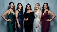 Five diverse women in elegant evening gowns posing together for formal portrait. Professional studio photography with soft lighting and neutral backdrop.