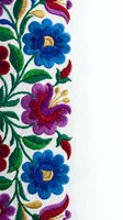 Colorful embroidered floral pattern with blue and purple flowers on white fabric. Traditional needlework design for textile decoration and craft projects.