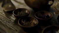 Dark moody composition with dried herbs and flowers in rustic wooden bowls on textured surface, atmospheric lighting creates mystical ambiance for wellness concept.
