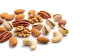 Mixed nuts collection with almonds walnuts pecans cashews pistachios on white background. Healthy snack protein source for cooking baking recipes.