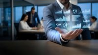 Businessman in light blue shirt holding digital analytics dashboard with charts and graphs, colleagues working in blurred office background, data visualization for business intelligence and financial reporting.