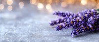 Fresh lavender flowers on rustic surface with warm bokeh lights creating peaceful spa atmosphere for aromatherapy and wellness designs.