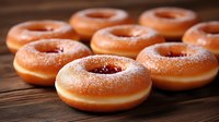 Fresh glazed donuts with sugar coating arranged on wooden surface, sweet bakery treats perfect for breakfast menu and food photography projects.