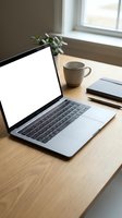 Modern laptop with blank white screen on wooden desk beside coffee cup and plant in bright home office workspace for remote work and productivity.