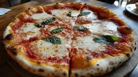 Fresh Neapolitan style pizza with melted mozzarella, tomato sauce and basil leaves on rustic wooden table, traditional Italian cuisine close-up view.