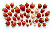 Fresh ripe strawberries in various sizes arranged on white background, ideal for food, nutrition, healthy eating, and recipe design projects.