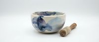 Handmade ceramic tea bowl with blue watercolor landscape design and wooden whisk on white background, isolated for product display and design use.