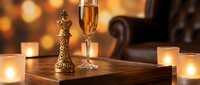 Elegant champagne flute with golden bubbles on wooden table surrounded by warm candlelight creating luxurious romantic atmosphere for celebration.