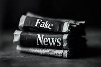 Rolled newspapers with text overlay highlighting media misinformation concept in dramatic black and white composition, emphasizing journalism and truth in reporting.