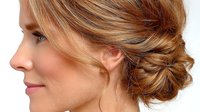 Elegant blonde woman with sophisticated low bun hairstyle showcasing professional updo styling for formal events, weddings, and business occasions.