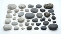 Collection of smooth river rocks and pebbles in various sizes, colors and textures isolated on white background for natural design projects.