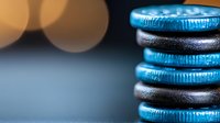Stacked chocolate sandwich cookies with blue cream filling against blurred bokeh background, macro food photography showing texture and layers.