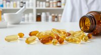 Vitamin supplements spilling from amber bottle on pharmacy counter with pharmacist in background. Health and wellness concept for medical care.